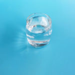 A glass of water on a blue background.